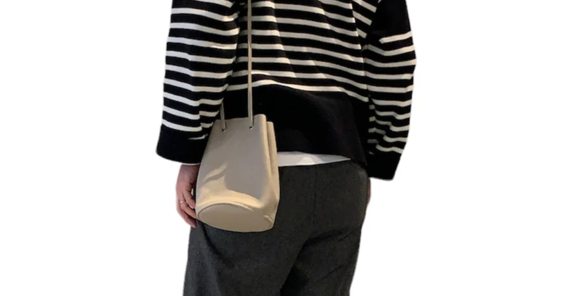 白と黒のボーダートップスを着た人が白色の巾着ショルダーバッグを持っている。