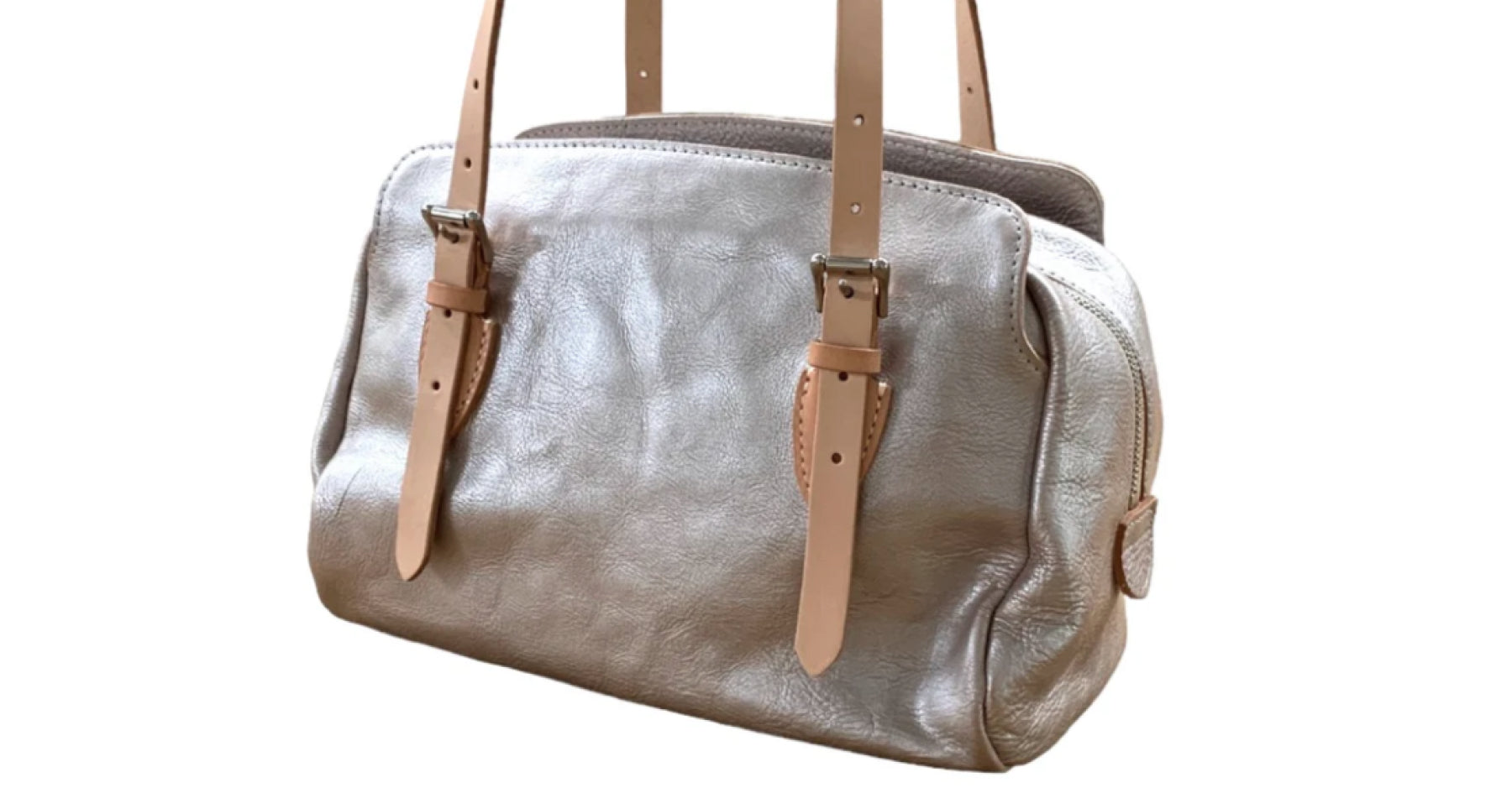 ベージュの持ち手がついたシルバーのバッグ。